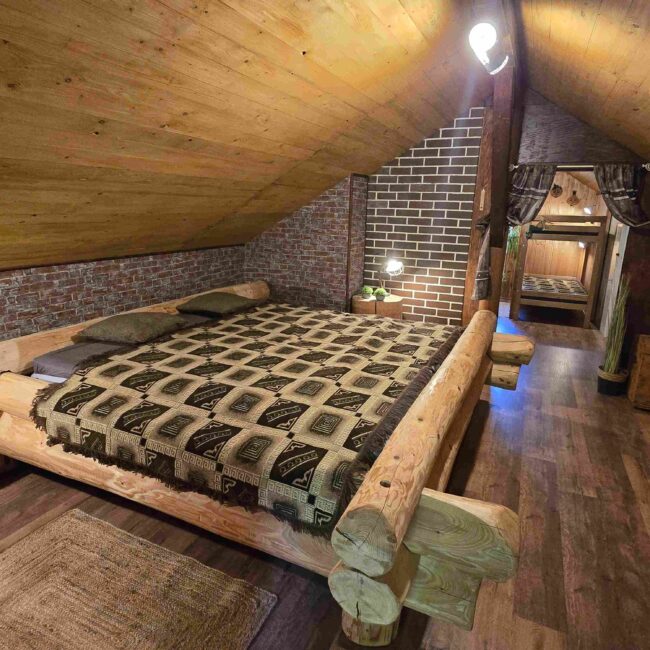 Großes Doppelbett aus rustikalem Holz in einem gemütlich eingerichteten Schlafzimmer