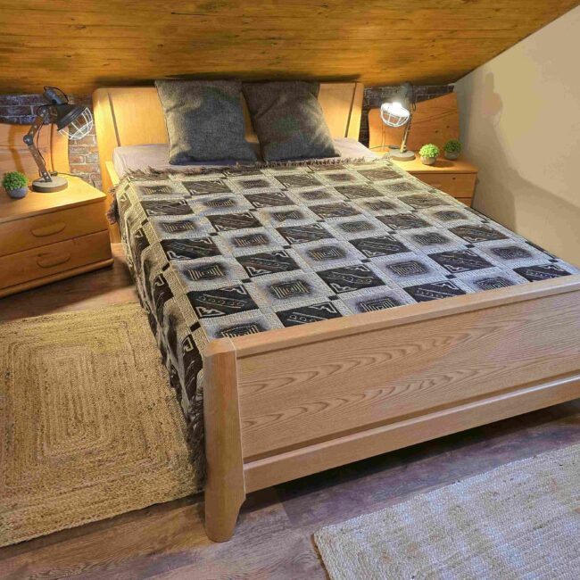 Kleines Doppelbett aus Holz in einem gemütlich und rustikal eingerichteten Schlafzimmer