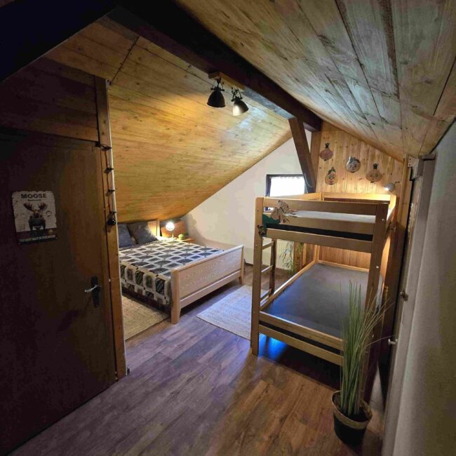 Schlafzimmer mit Etagenbett und kleinem Doppelbett aus Holz